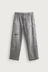 Jeans relaxed fit de tiro medio y pernera recta confeccionados en denim de algodón rígido, con diseño de carpintero que incluye bolsillos superpuestos y roturas localizadas en el frente.