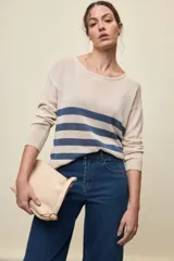 Sweater liviano de punto color beige con rayas horizontales azules, escote redondo amplio y mangas largas con puños acanalados.