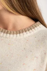 Sweater oversize de lana con diseño color block, combinando un cuerpo en tono crema con motas multicolores y una franja inferior ancha en color visón. Presenta cuello redondo y detalles acanalados en el cuello, puños y ruedo, además de franjas laterales texturizadas en las mangas.