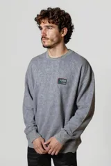 Buzo gris oscuro con cuello redondo y parche con la bandera de Estados Unidos en el pecho.