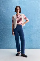 Jean de tiro alto con corte recto, confeccionado en denim con spandex. Presenta un lavado gris oscuro con efecto desgastado, cierre frontal con botón y bolsillos laterales y traseros.