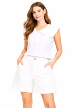 Blusa blanca sin mangas con cuello Peter Pan grande con volados en el borde. Cierre frontal con botones.