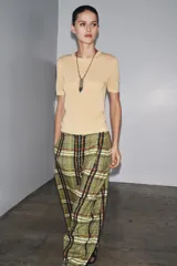 Top de manga corta color beige claro, con cuello redondo y textura de tejido de punto fino.