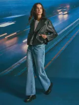 Chaqueta corta de cuero sintético en color negro, con diseño de doble botonadura, solapas amplias y corte holgado.