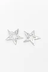 Aros caravanas en forma de estrella con diseño calado, acabado plateado y textura irregular.