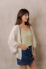 Kimono marfil de silueta amplia, confeccionado en tela con bordados florales y detalles calados. Cuenta con mangas amplias tres cuartos, frente abierto y terminaciones decorativas.