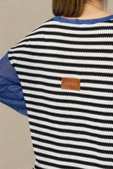 Buzo tejido a rayas horizontales en blanco y negro, con mangas largas de tejido con lurex azul.