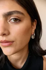 Aros de argolla en acero quirúrgico con dije de piedra natural en tono azul.