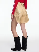 Bermuda color beige con efecto laminado dorado, tiro alto, corte amplio, largo a medio muslo y ruedo desflecado.