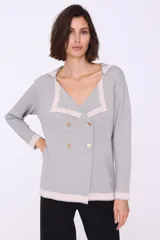 Cárdigan color beige con cuello marinero con borde gris, doble botonadura dorada y mangas largas. Tejido de punto.