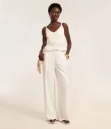 Pantalón wide leg de cintura alta, confeccionado en viscolino color blanco, con trabillas en la cintura, elástico atrás de la cintura, cierre tradicional, pliegues y cinturón de cuerda.