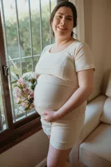 Pijama corto gris a rayas horizontales, apto para embarazo y lactancia. Incluye remera de manga corta con apertura para amamantar y short con elástico ajustable en la cintura. Detalles de puntilla elastizada en remera y short.