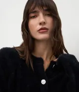 Cardigan de tricot con textura efecto peluche, color negro, de calce regular, escote redondeado y cierre frontal con botones.