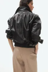 Pantalón sastrero de tiro alto con corte recto, confeccionado con pretina prolongada, cierre frontal, bolsillos laterales y detalle de bolsillo monedero con solapa en la cintura.