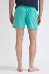 Short de baño liso en color verde, con corte recto y elástico en la cintura.