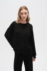 Buzo negro de punto canalé, corte holgado, cuello redondo y mangas largas.