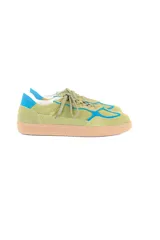Championes de estilo deportivo retro, confeccionados en una combinación de cuero y gamuza en tonos verde palta y detalles en azul vibrante. Presentan suela de goma color caramelo con textura estriada y cordones al tono.
