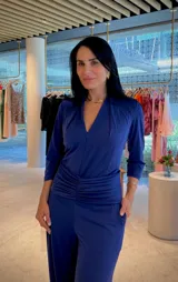 Mono largo color rojo, con escote en V, mangas 3/4 y detalle de faja fruncida en la cintura. Incluye bolsillos laterales.