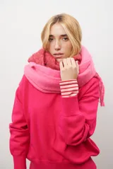 Buzo de punto color fucsia, con cuello redondo y mangas largas.