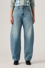 Pantalón de jean de corte baggy con diseño barrel, tiro medio y lavado azul claro con efecto desgastado. Presenta costuras laterales curvadas que definen su silueta amplia y relajada.