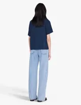 Remera oversize de algodón azul marino con efecto lavado, cuello redondo, mangas cortas y estampa frontal con texto en tono claro.