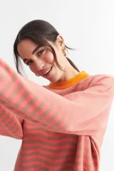 Sweater de punto a rayas horizontales verdes y blancas con cuello redondo en color coral.