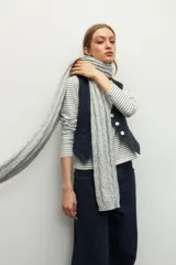Bufanda de punto gris con diseño de ochos y calados verticales, confeccionada en tejido suave.