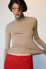 Jersey de punto con lana, color celeste, de cuello subido y manga larga, con diseño ajustado al cuerpo.