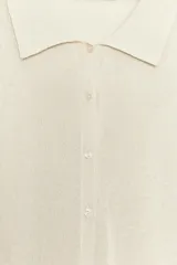 Chaqueta de punto de cuello polo y manga larga con cierre frontal de botones. Incluye un top interior a juego de escote redondo y tirantes finos.