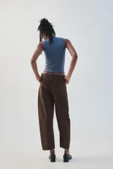 Jeans de tiro medio color marrón con diseño de volumen crop, silueta holgada en las piernas y cinco bolsillos tradicionales. Cierre frontal con cremallera y botón metálico.