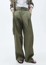 Pantalon wideleg de tiro alto en color verde militar, con detalle de pinzas delanteras, trabillas y cinturón incorporado con hebilla metálica. Cuenta con cierre frontal de botón, gancho y cremallera, además de bolsillos laterales.