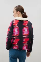 Campera con estampado de bosque en tonos azules, cuello de sherpa en color crema y cierre frontal con cremallera. Cuenta con elástico ajustable en la cintura.