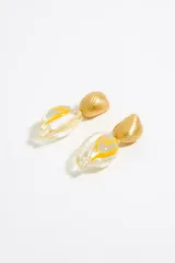 Aros colgantes con forma de caracola, con base dorada con textura acanalada y dije de resina transparente con diseño abstracto en amarillo.