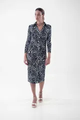 Vestido midi de corte ajustado, con estampado animal print tipo cebra en blanco y negro, cuello camisero, escote en V y cierre frontal con botones dorados.