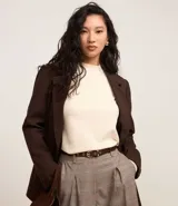 Suéter de punto color crema, con cuello alto, mangas largas y detalle de costura vertical en relieve en la parte frontal.