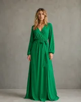 Vestido largo verde con escote cruzado en V, mangas largas amplias con puños elásticos y lazo ajustable en la cintura.