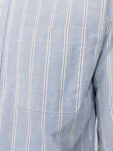 Camisa de vestir de manga larga con cuello abotonado y bolsillo frontal. Presenta un diseño de rayas verticales en tonos azul y blanco, con cierre frontal de botones.