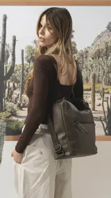 Cartera convertible en mochila de diseño versátil, color tostado, con textura granulada. Cuenta con un bolsillo frontal con cierre, compartimento principal espacioso y correas ajustables para llevar al hombro o como mochila.