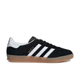 Championes Adidas Gazelle Indoor negros con las tres tiras blancas y suela color caramelo.