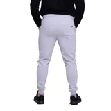 Pantalón de jogging gris melange con cintura elástica y cordón ajustable, puños en los tobillos y logo bordado en la pierna izquierda.