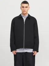 Campera estilo worker de color negro, con cierre frontal de cremallera, cuello clásico y dos bolsillos frontales. Presenta un diseño de corte recto y tejido liviano.