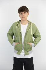 Campera verde oliva de nylon anti-lluvia, con capucha, cierre frontal y puños y cintura en tejido de punto gris. Presenta un logo bordado en el pecho.