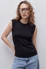 Remera sin mangas de silueta entallada y corte al cuerpo, confeccionada en algodón elastizado con textura acanalada y escote redondo.