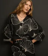 Blusa negra con estampado de hojas en color crema, escote en V y mangas 7/8.