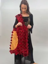 Bolso de gran tamaño confeccionado artesanalmente con técnica de ensamblado de cuadrados de lana merino afiltrada en tonos violeta y gris. Presenta un diseño texturizado y voluminoso, con forro interior de algodón y bolsillo con cierre.