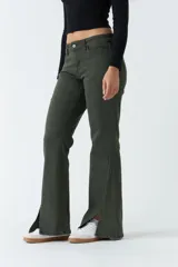 Pantalón negro de tiro medio, corte ajustado en la cadera y piernas que se ensanchan. Presenta cortes en el bajo de cada pierna.