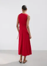 Vestido midi color rojo, sin mangas, con cuello redondo y aberturas laterales en la cintura con tiras ajustables.