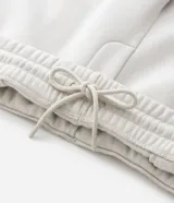 Pantalón jogger de algodón con felpa, color beige, con cintura elástica, cordón ajustable, bolsillos laterales y puños elásticos en los tobillos.