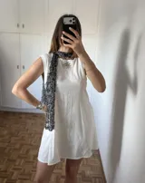 Bufanda tejida artesanalmente con hilado fantasía de textura abierta y brillo sutil. Diseño liviano y versátil que puede utilizarse como bufanda o mini chal.