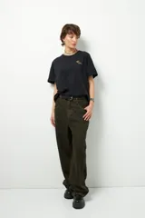 Remera negra de corte oversize con cuello redondo y manga corta. Presenta un pequeño estampado dorado en el pecho con la frase "love earth" y un símbolo de hojas.